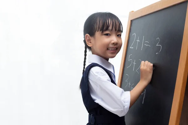 亚洲的中国小女孩在孤立的白色背景在黑板上写 — 图库照片