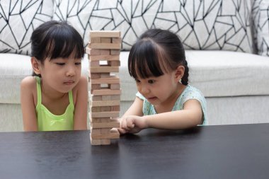 Asyalı Çinli küçük kız ahşap yığınları evde oynarken