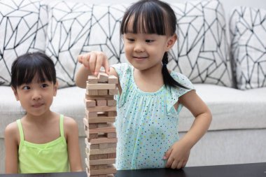 Asyalı Çinli küçük kız ahşap yığınları evde oynarken