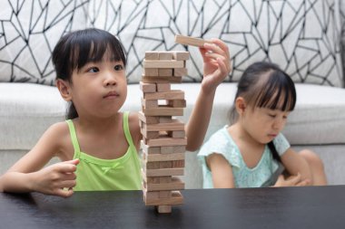 Asyalı Çinli küçük kız ahşap yığınları evde oynarken