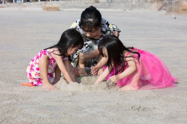 Asya Çin anne ve kızı oynamaya birlikte beach adlı açık kum