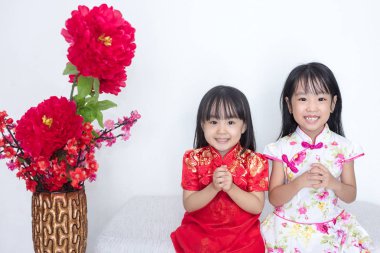 Asyalı Çinli küçük kız cheongsam Çin yeni yılı için jest kutlama tebrik ile giyiyor