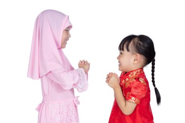 Asyalı Çinli küçük kız cheongsam ve geleneksel Malay jest izole beyaz arka planda tebrik ile kostüm