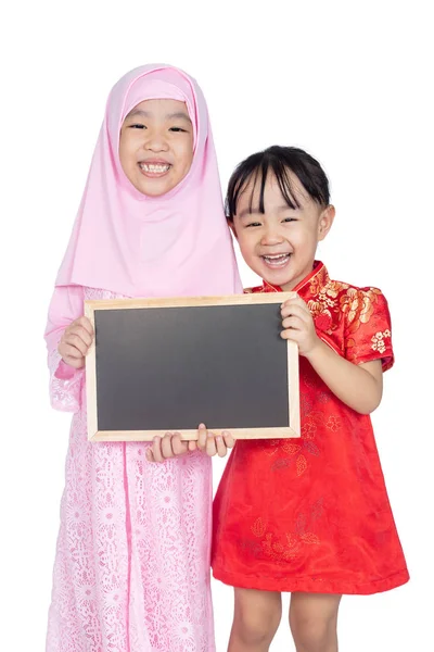 亚洲华人小姐妹身穿旗袍和传统马来服装 在隔绝的白色背景下一起手持黑板 — 图库照片