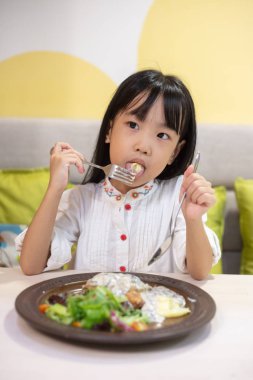 Asyalı küçük Çin kız yemek Western yemeği restoranda