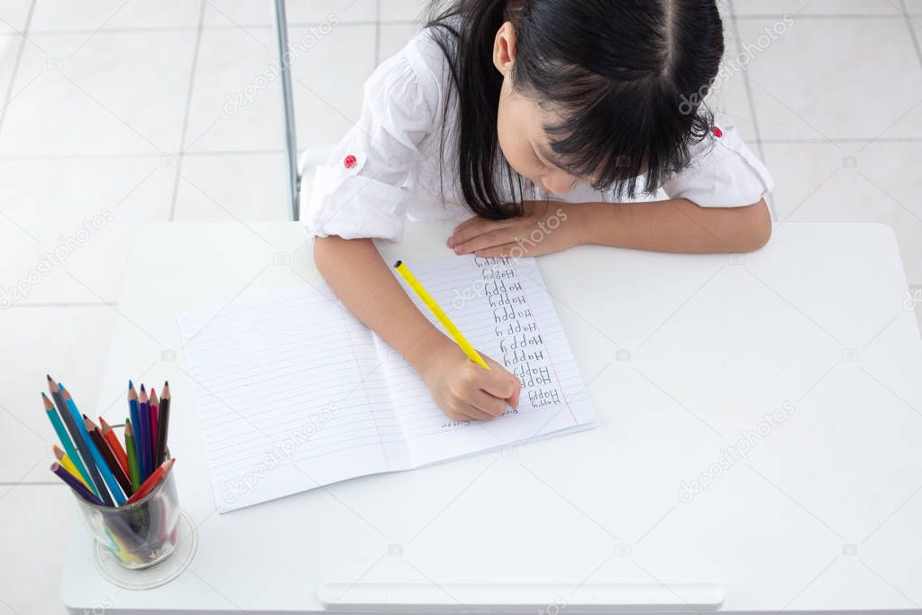 Asian Little Chinese girl doing homework at home