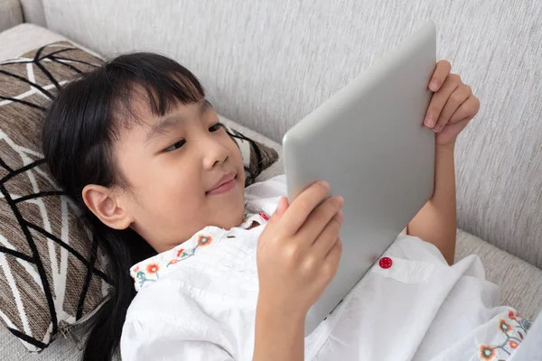 Asiática China Niña Acostada Sofá Jugando Tableta Sala Estar — Foto de Stock