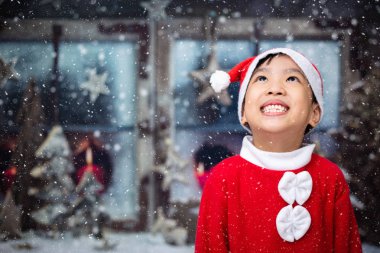 Asyalı Çinli küçük kız kar taneleri Yılbaşı sırasında açık izlerken