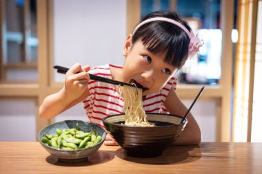 Asyalı küçük Çinli kız ramen noodle bir Japon restoranında yemek