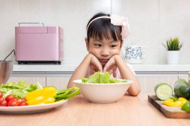 Asyalı Çinli küçük kız salata evde mutfakta yemek