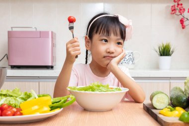 Asyalı Çinli küçük kız salata evde mutfakta yemek