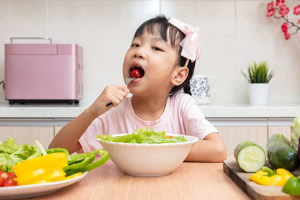 Asyalı Çinli küçük kız salata evde mutfakta yemek