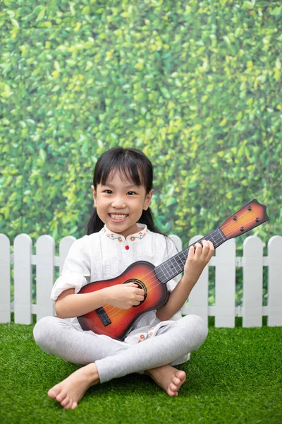 Asiático Poco China Chica Sentado Hierba Jugando Con Guitarra Aire —  Fotos de Stock