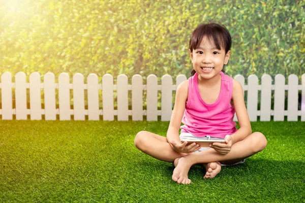 アジアの中国の女の子が屋外の公園で携帯電話で遊んで — ストック写真