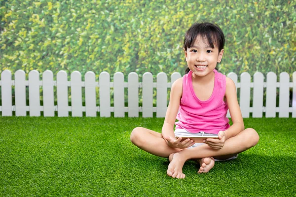 アジアの中国の女の子が屋外の公園で携帯電話で遊んで — ストック写真