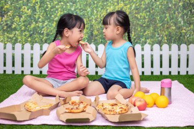 Asyalı Çinli küçük kız açık Garden'da pizza yemek