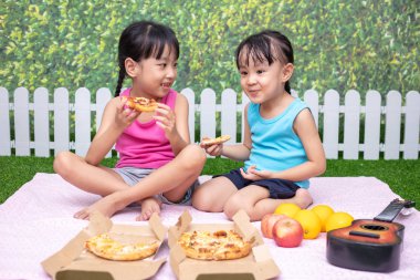 Asyalı Çinli küçük kız açık Garden'da pizza yemek