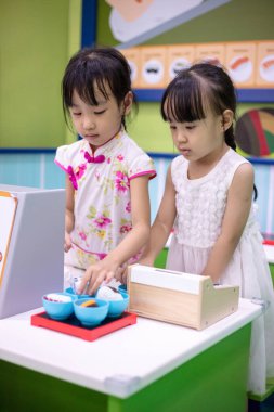 Asyalı Çinli küçük kız suşi rol yapma kapalı Bahçesi depolamak