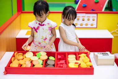 Asyalı Çinli küçük kız burger rol yapma kapalı oyun alanı saklamak