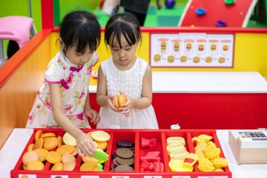 Asyalı Çinli küçük kız burger rol yapma kapalı oyun alanı saklamak