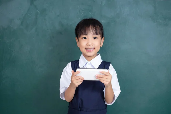 Asiática China Niña Uniforme Jugando Digital Tableta Contra Verde Pizarra — Foto de Stock