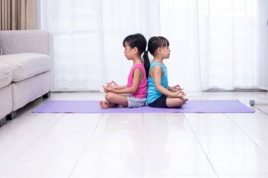 Asyalı Çinli küçük kız pratik yoga mat evde oturma odasında poz