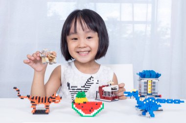 Asyalı Çinli küçük kız puzzle oyuncakları oynuyor