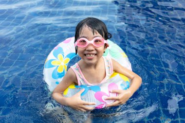 Asyalı küçük Çinli kız yüzme havuzunda oynayan