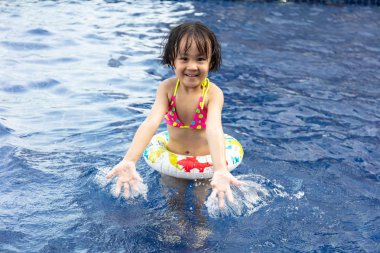 Asyalı küçük Çinli kız yüzme havuzunda oynayan