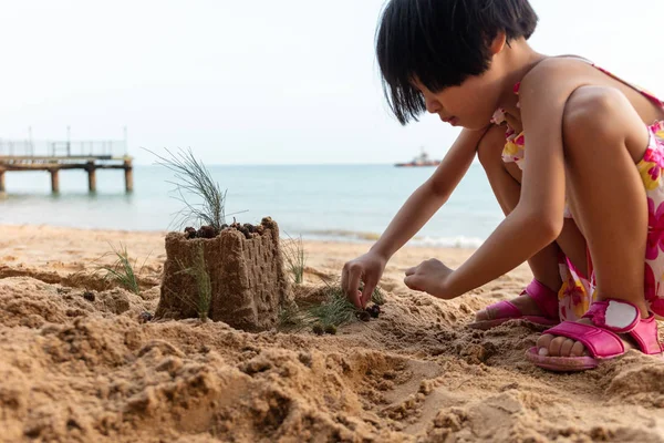 Ázsiai kínai kis lány játék homokos strandon — Stock Fotó