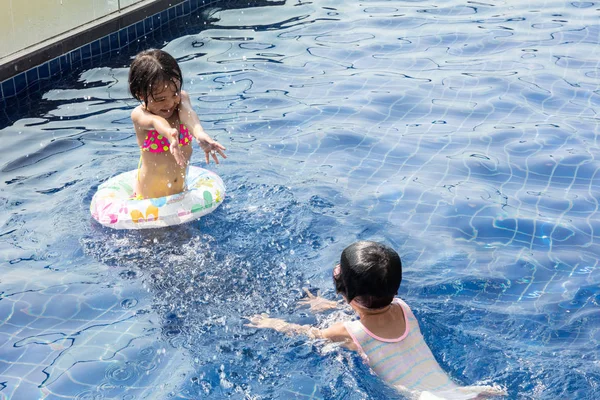 Asya küçük Çinli Sisters yüzme havuzunda oynuyor — Stok fotoğraf