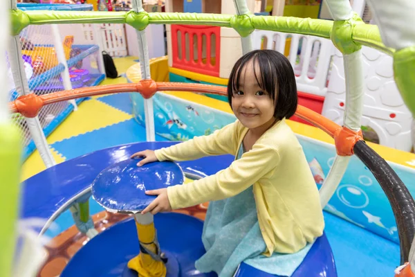 Азиатская маленькая китайская девочка сидит на карусели — стоковое фото