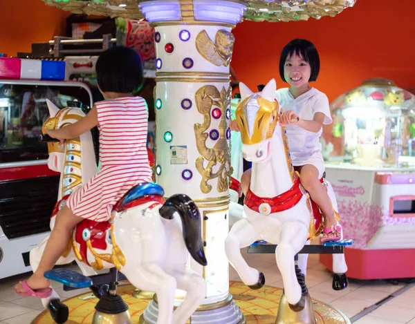 Asian Little Chinese Sisters playing at amusement Stock Image