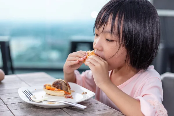 Ásia pouco chinês menina comer hambúrguer — Fotografia de Stock