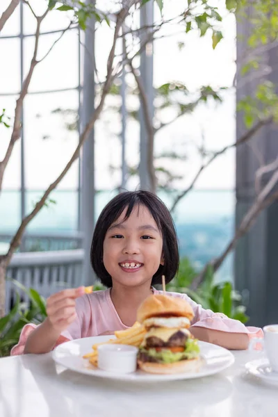Asiática poco china chica comer hamburguesa —  Fotos de Stock