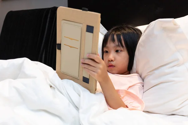 Asiática poco china chica jugando con tablet en cama — Foto de Stock