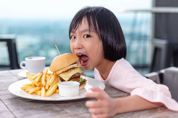 Asiática poco china chica comer hamburguesa —  Fotos de Stock