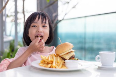 Asyalı Küçük Çinli Kız hamburger yeme 