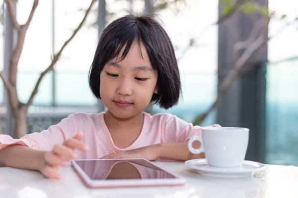 Asiática poco china chica jugando con tablet — Foto de Stock