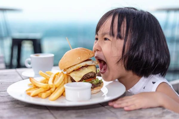 Asian Little Chinese Girl eating hamburger — Stock Photo, Image