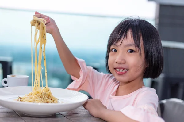 Asiatische kleine chinesische Mädchen essen Spaghetti lizenzfreie Stockfotos
