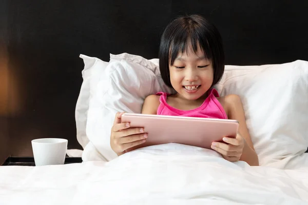 Asian Little Chinese Girl gry tablet w łóżku — Zdjęcie stockowe