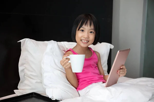 Asiático poco china chica jugando tableta en cama — Foto de Stock