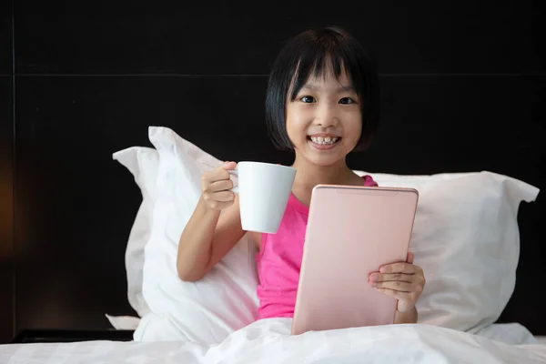 Asiatico piccolo cinese ragazza giocare tablet in letto — Foto Stock