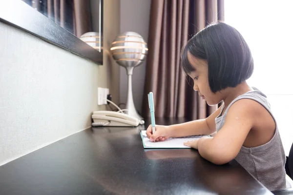 Asian Little Chinese Girl doing homework Stock Photo