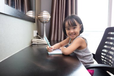 Asyalı Küçük Çinli Kız ev ödevi yapıyor