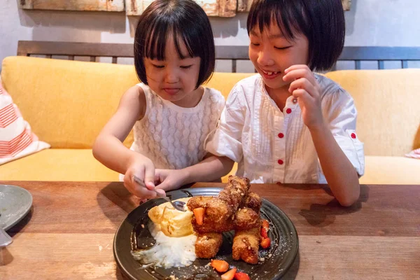 Asiatiska små kinesiska systrar äter frukost Stockbild
