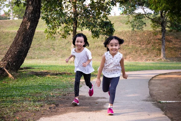 Asiatische kleine chinesische Schwestern laufen glücklich lizenzfreie Stockbilder