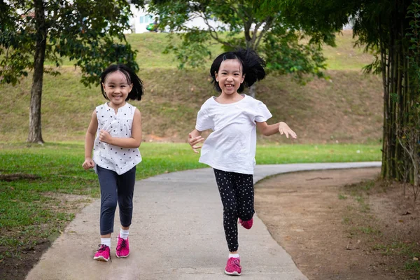 Aziatische kleine Chinese zusters rennen gelukkig Stockfoto