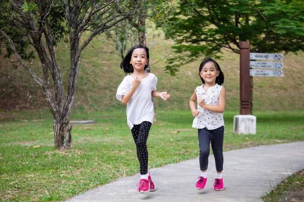 Asiatische kleine chinesische Schwestern laufen glücklich lizenzfreie Stockfotos